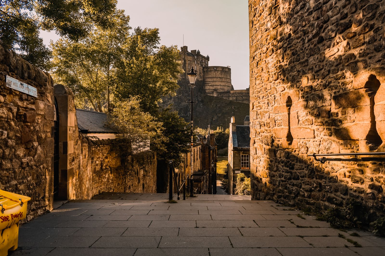 Edinburgh Castle above the stone steps and historic buildings of the Vennel